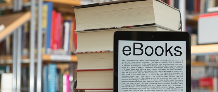 Ebook reader in front of stack of book