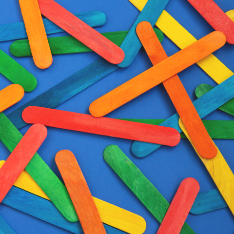 Image of colorful popsicle sticks on a blue background