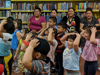 Children and caregivers attending a Neighbors Link Family Center event at the library