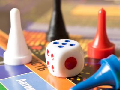 Image of a board game with 4 game pieces and one die 