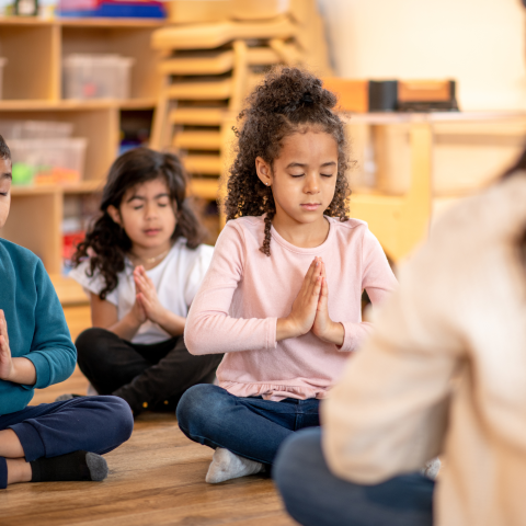 Children doing yoga in a classroom setting