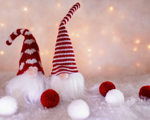 Image of gnome decorations wearing red hats, in front of a glowy background