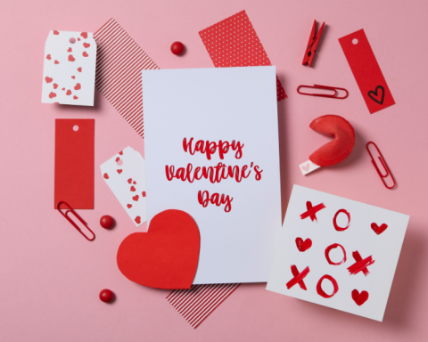 Image of a card that says "Happy Valentines Day" written in red writing, on a pink background