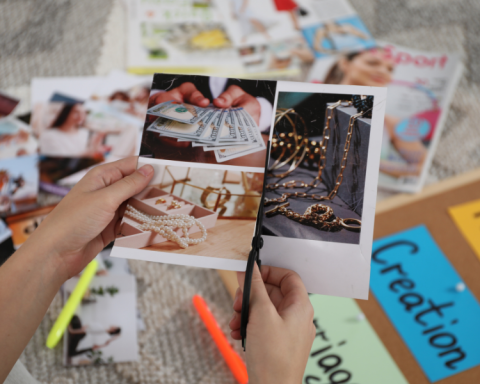 Image of hands cutting out photos and placing them onto a vision board