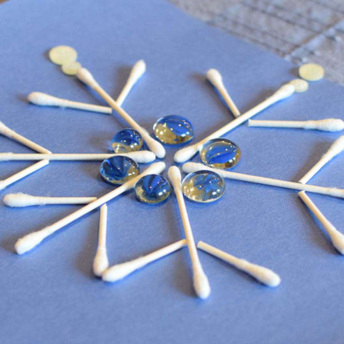 Image of loose pieces like cotton balls and stones making a snowflake design